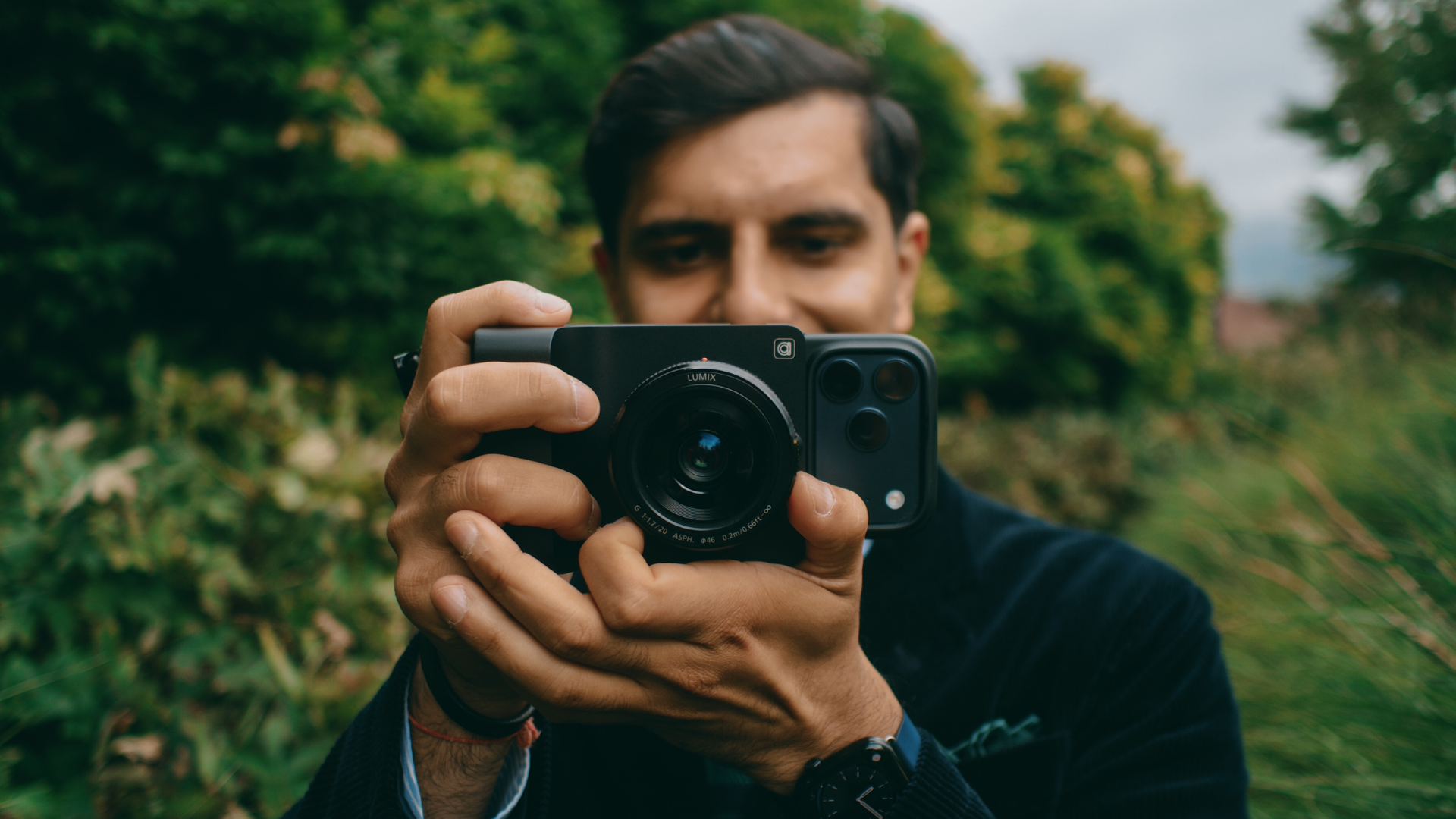 Headshot of Vishal Kumar, Camera Intelligence's co-founder, holding one of the company's Caira units and pointing it at the camera.